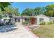 Inviting single-story home with a concrete driveway and a well-manicured lawn surrounded by mature trees at 4425 W Bay Villa Ave, Tampa, FL 33611