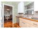 Kitchen featuring light wood cabinets, stainless steel appliances, and decorative wallpaper at 4425 W Bay Villa Ave, Tampa, FL 33611