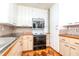 Kitchen with white cabinets, black countertops, and modern appliances at 4425 W Bay Villa Ave, Tampa, FL 33611