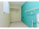 Functional laundry room with tiled floors, built-in shelves, and utility connections at 4425 W Bay Villa Ave, Tampa, FL 33611