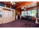 Living room with wood paneling, purple carpet, and a black leather couch at 4425 W Bay Villa Ave, Tampa, FL 33611
