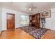 Spacious living area featuring hardwood floors, a ceiling fan, and an ornate wooden desk at 4425 W Bay Villa Ave, Tampa, FL 33611