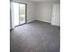 Spacious bedroom with neutral carpet and a sliding glass door at 455 Alt 19 S # 235, Palm Harbor, FL 34683
