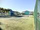 Community tennis court surrounded by lush landscaping and multiple residences at 455 Alt 19 S # 235, Palm Harbor, FL 34683