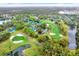 An aerial view of a golf course and pond surrounded by a residential community at 50 Balsam Dr, Oldsmar, FL 34677