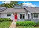 Charming single-story home featuring a red door with wreath and a well-maintained front lawn at 50 Balsam Dr, Oldsmar, FL 34677