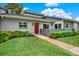 Charming home exterior with a well-manicured lawn, a walkway, and a vibrant red front door at 50 Balsam Dr, Oldsmar, FL 34677