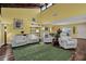 Bright living room boasts vaulted ceilings, wood beams, wood floors, and comfortable white furniture at 50 Balsam Dr, Oldsmar, FL 34677