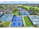 An aerial view of tennis and pickleball courts surrounded by lush greenery and community amenities at 50 Balsam Dr, Oldsmar, FL 34677