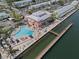 Expansive aerial view showcasing waterfront condos, a pool, and a long fishing pier at 5174 Beach Se Dr # B, St Petersburg, FL 33705