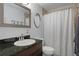 The bathroom features a dark granite vanity and a shower with a neutral-toned shower curtain at 5174 Beach Se Dr # B, St Petersburg, FL 33705