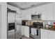 Efficient kitchen design with stainless steel appliances, granite countertops, and white cabinets at 5174 Beach Se Dr # B, St Petersburg, FL 33705