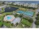 Aerial view of a community pool, tennis courts, and a serene pond with a fountain at 5174 Beach Se Dr # B, St Petersburg, FL 33705