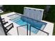 A tranquil pool with a modern waterfall feature and comfortable lounge seating, surrounded by green landscaping at 519 W Davis Blvd, Tampa, FL 33606