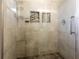 Modern shower with glass door, neutral tiling, built-in shelves, and sleek fixtures at 551 84Th N Ave, St Petersburg, FL 33702