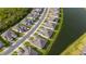 Aerial view of homes in a neighborhood, next to a pond with lush greenery and tree-lined streets at 5735 Mezzana Run, Palmetto, FL 34221