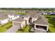 Aerial shot of a home with a brick driveway, landscaping, and a two-car garage plus a one car garage at 5735 Mezzana Run, Palmetto, FL 34221