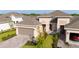 Aerial shot of a home with a brick driveway, landscaping, and a two-car garage plus a one car garage at 5735 Mezzana Run, Palmetto, FL 34221