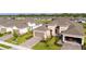 Aerial shot of a home with a brick driveway, landscaping, and a two-car garage plus a one car garage at 5735 Mezzana Run, Palmetto, FL 34221