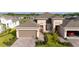 Aerial shot of a home with a brick driveway, landscaping, and a two-car garage plus a one car garage at 5735 Mezzana Run, Palmetto, FL 34221