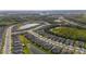 Expansive aerial shot showcasing a Primary-planned community with lush greenery, scenic ponds, and neatly arranged homes at 5735 Mezzana Run, Palmetto, FL 34221