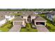 Aerial shot of a home with a brick driveway, landscaping, and a two-car garage plus a one car garage at 5735 Mezzana Run, Palmetto, FL 34221