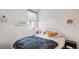 Cozy bedroom with natural light, a comfortable bed and minimalist decor on floating shelves at 5735 Mezzana Run, Palmetto, FL 34221
