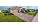 A large paver driveway leads to the house, complemented by lush green lawns and some plants at 5735 Mezzana Run, Palmetto, FL 34221