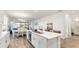 A kitchen island with quartz countertops overlooks the dining and living spaces in this open-concept design at 5735 Mezzana Run, Palmetto, FL 34221