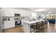 Open-concept kitchen with white cabinets, stainless appliances, large island and seamless flow to dining and living areas at 5735 Mezzana Run, Palmetto, FL 34221