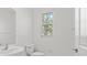 Modern bathroom featuring a sleek sink, a toilet and a window for natural light at 7018 Ripple Pond Loop, Zephyrhills, FL 33541