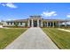 Stunning clubhouse with a pathway leading to the double door entry and well-manicured lawn at 7018 Ripple Pond Loop, Zephyrhills, FL 33541