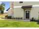 Welcoming front entrance features a stylish black door, stone accents, and well-manicured landscaping at 7018 Ripple Pond Loop, Zephyrhills, FL 33541