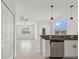 Bright kitchen boasts stainless steel appliances, pendant lighting, and granite countertops, open to the living area at 7018 Ripple Pond Loop, Zephyrhills, FL 33541