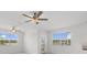 Bright living room with two ceiling fans, large windows, and patio doors at 7018 Ripple Pond Loop, Zephyrhills, FL 33541