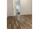 Bedroom with wood-look flooring and a doorway leading to a bathroom at 7321 Isle Dr, Port Richey, FL 34668