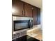 A stainless steel Frigidaire microwave adorns the kitchen, complementing the dark wood cabinets at 7321 Isle Dr, Port Richey, FL 34668