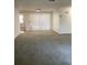 Bright and airy living room featuring neutral walls, plush carpeting, and a sliding glass door at 7321 Isle Dr, Port Richey, FL 34668