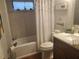 Cozy bathroom features tub with shower, wood-look floor, and decorative accents at 7941 Clarendon Dr, New Port Richey, FL 34654