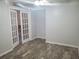 Neutral bedroom with double doors and wood-look flooring offers a peaceful retreat at 7941 Clarendon Dr, New Port Richey, FL 34654