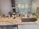Kitchen island with stainless steel sink, countertops, and a view of the living room at 7941 Clarendon Dr, New Port Richey, FL 34654
