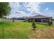 Large backyard, enclosed with a privacy fence, featuring a well-maintained lawn and a covered patio area at 803 Floresta St, Brandon, FL 33511