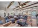 Open-concept living space featuring a large sectional sofa, wooden beams, and an open view to the kitchen at 803 Floresta St, Brandon, FL 33511