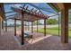 A covered patio features a brick floor, a wooden pergola, and a modern fire pit for outdoor relaxation and entertainment at 803 Floresta St, Brandon, FL 33511