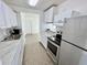 Bright kitchen featuring stainless steel appliances, white cabinetry, and marble countertops at 5604 Larimer Dr, Tampa, FL 33615