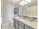 Neutral bathroom featuring granite countertops, modern fixtures, and a large mirror at 10106 Bessemer Pond Ct, Riverview, FL 33578