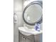 Stylish half-bathroom features a round mirror, modern vanity, and elegant decor at 10106 Bessemer Pond Ct, Riverview, FL 33578