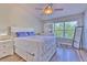 Bright bedroom features a large window, wood floors, and a comfortable bed at 10106 Bessemer Pond Ct, Riverview, FL 33578