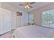 Bright bedroom features a ceiling fan, TV, and large window with a view at 10106 Bessemer Pond Ct, Riverview, FL 33578