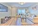 Bright living room with wood flooring, comfortable seating, and a large television at 10106 Bessemer Pond Ct, Riverview, FL 33578